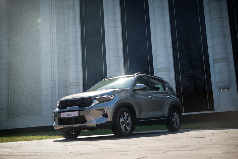 Kia Sonet в профиль у современного здания